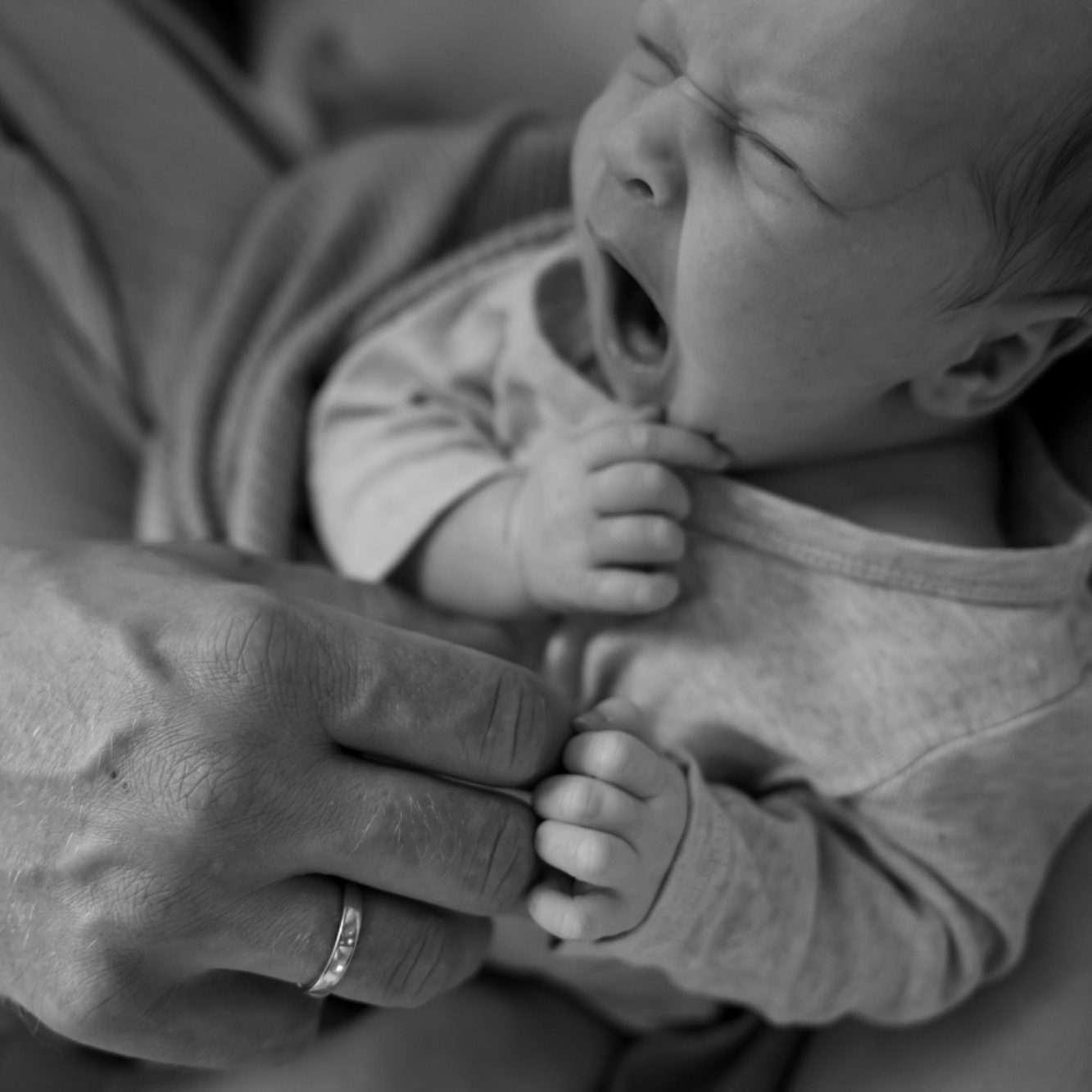 Familienshooting Eine Mutter hält ihr lächelndes Baby eng an sich.