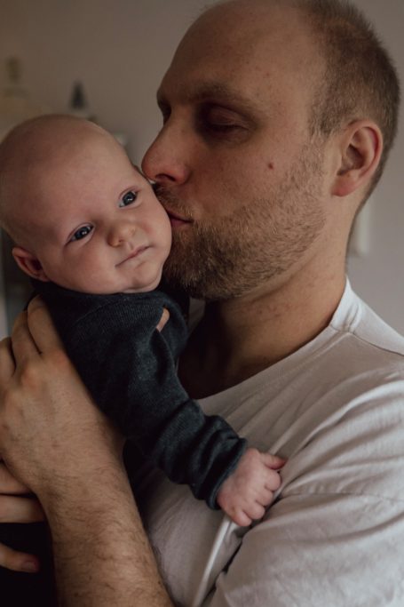 Vater küsst sein lächelndes Baby in einem liebevollen Moment.